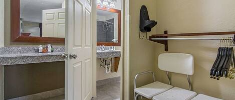 Un baño con espejo, lavamanos, ducha y retrete.