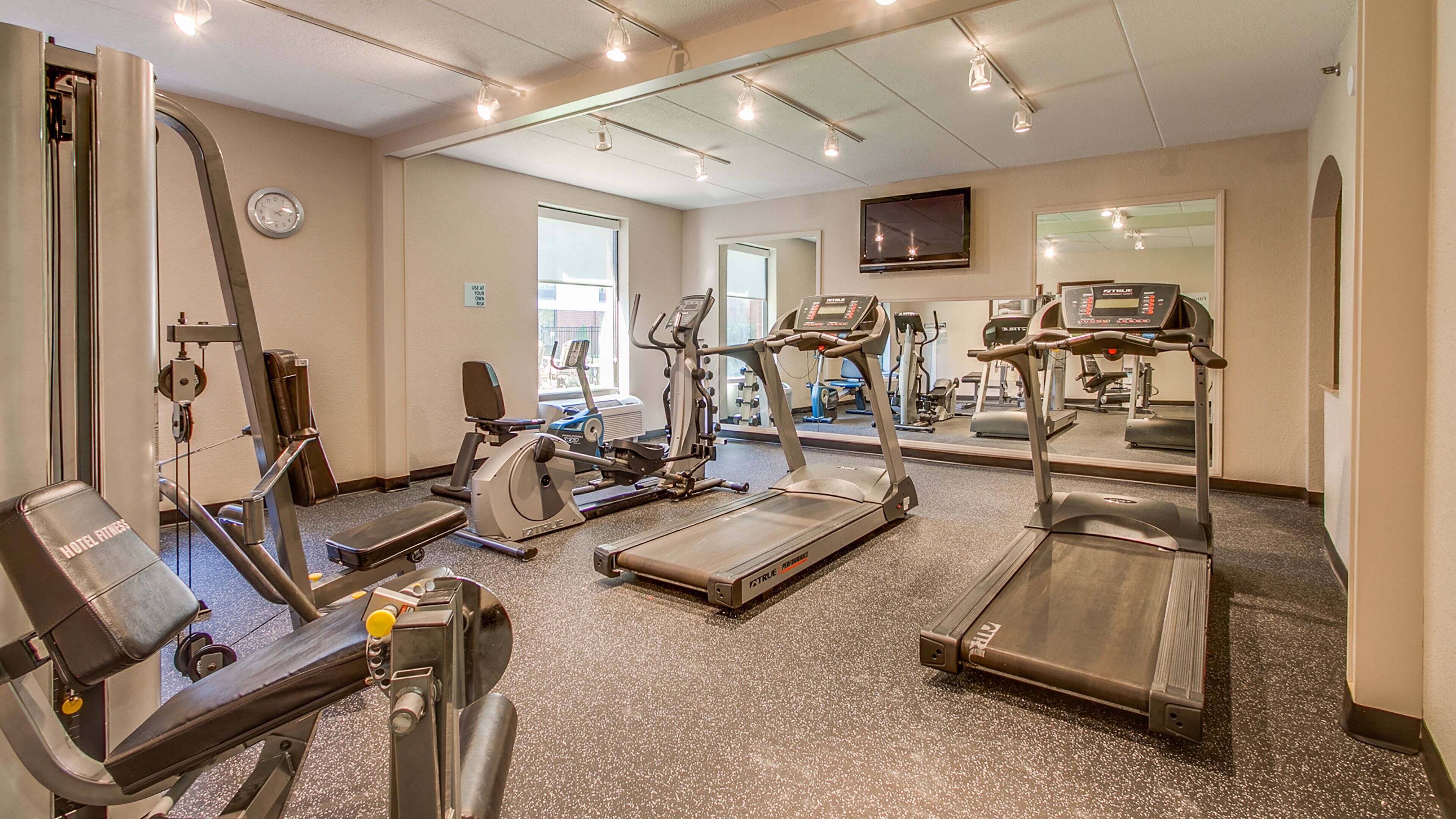 Ein Fitnessstudio mit Laufbändern, Ergometer und Krafttrainingsgeräten.