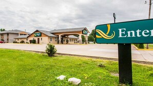 A Quality Inn hotel with a green sign, a covered outdoor area, and a parking lot. - Quality Inn Cairo I-57 (Cairo)
