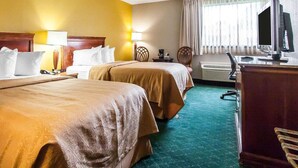 A hotel room with two beds, a desk with a computer, a television, and a window with curtains. - Quality Inn Cairo I-57 (Cairo)