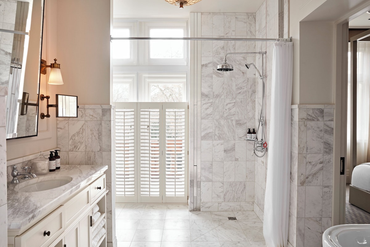 A modern bathroom with a shower, a vanity with a mirror, and a bathtub.