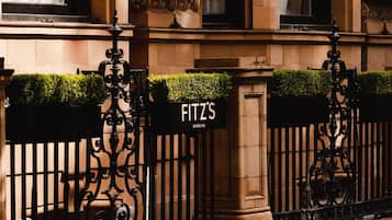 A wrought iron gate with a sign reading "Fitz's Russell Sq."