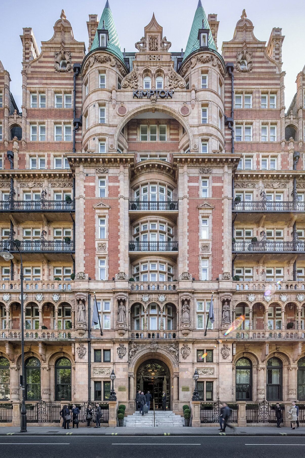 Een historisch gebouw met een centrale ingang, meerdere balkons en versierde architectuur.