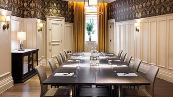 A conference room with a long table, chairs, and a cabinet.