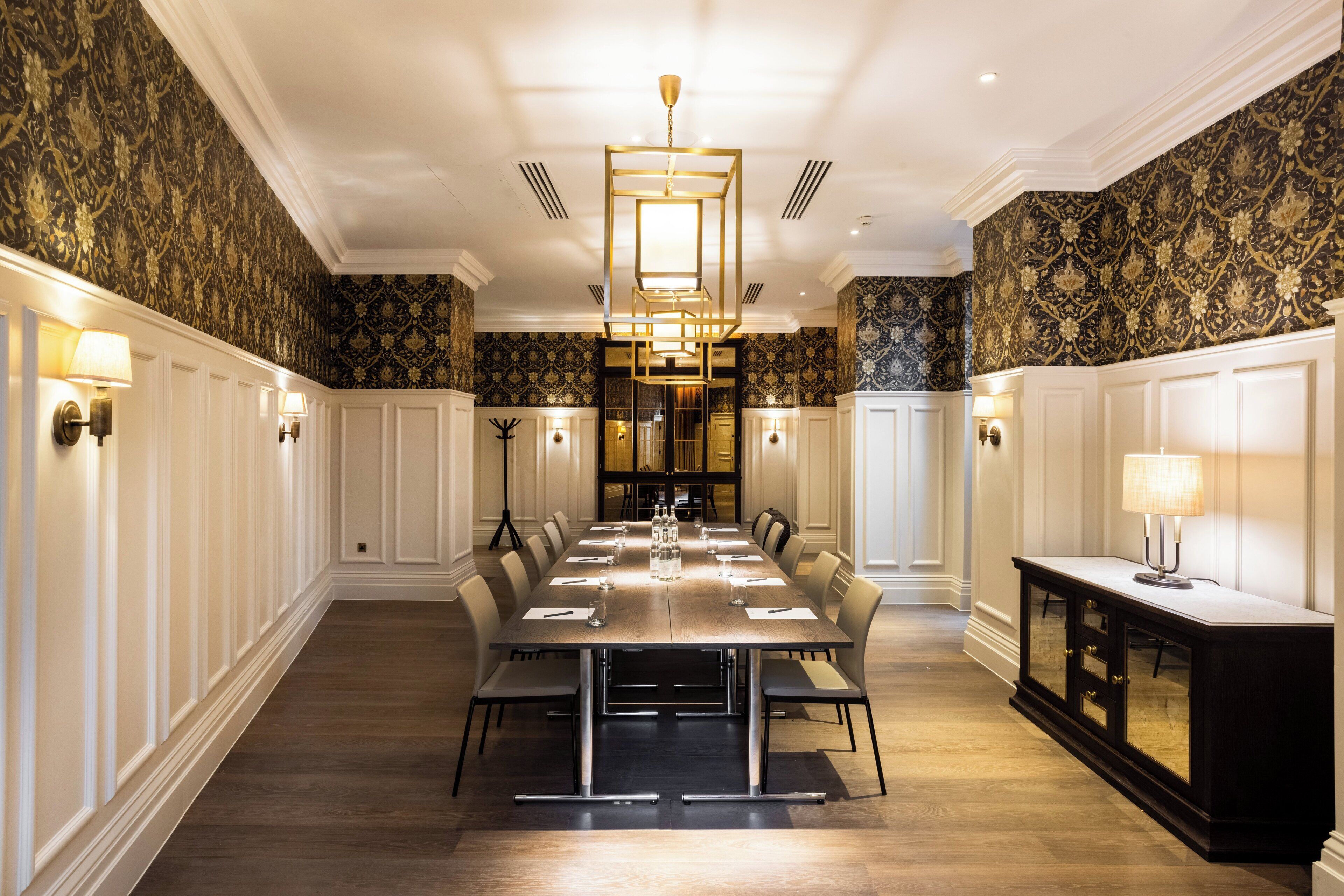 A formal dining room with a long table, chairs, and a chandelier.