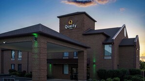 Ein Backsteinhaus mit einem Schild, auf dem „Quality Inn“ steht.