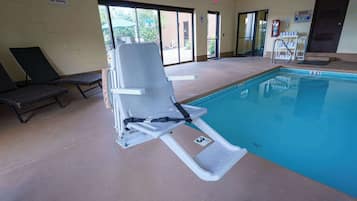 Een binnenzwembad, ligstoelen bij het zwembad