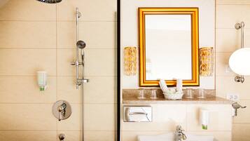 A bathroom with a shower, sink, and mirror.