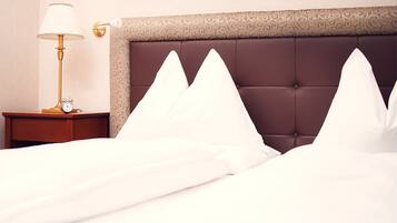 Una cama bien hecha con almohadillas blancas y un cabecero marrón.
