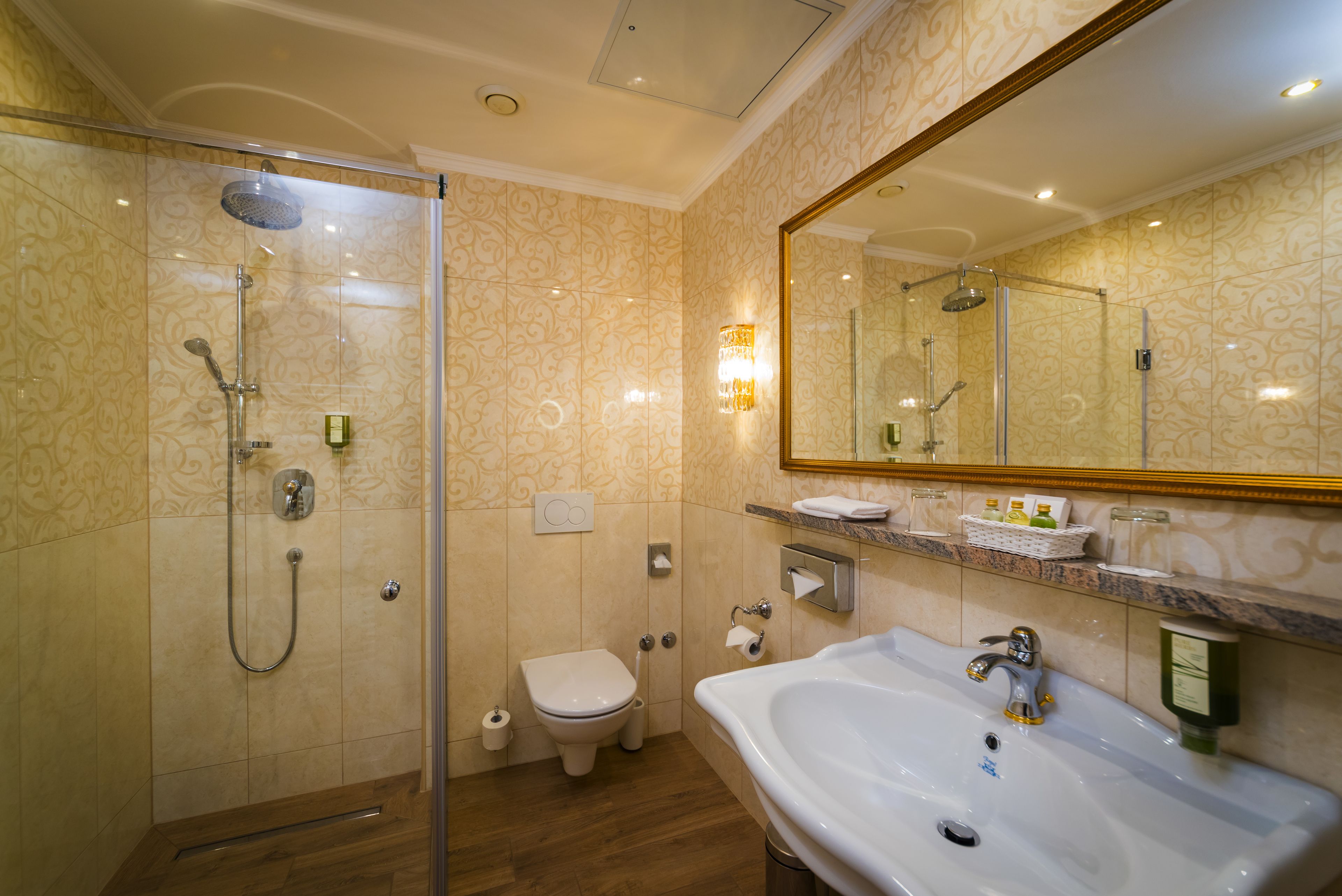 A modern bathroom with a glass-enclosed shower, a white sink, and a large mirror.