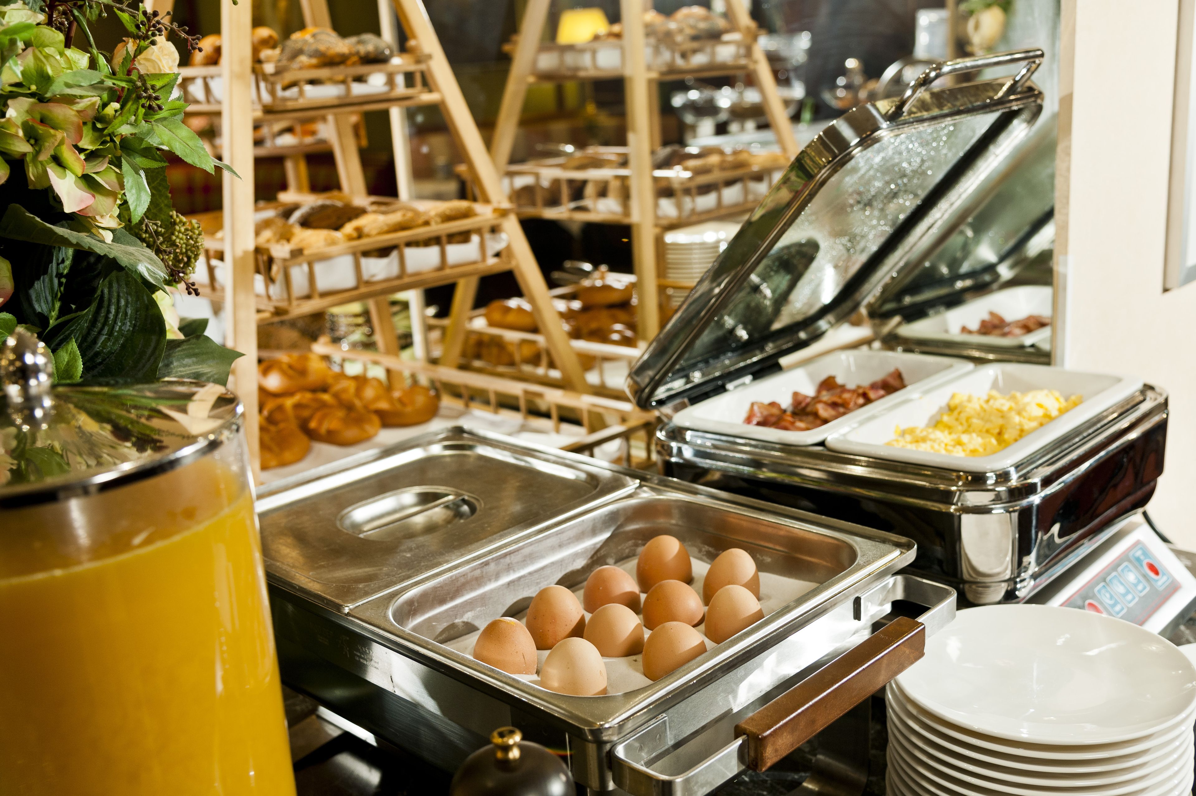 Un buffet con diversi cibi, tra cui uova, pancetta e pasticceria.