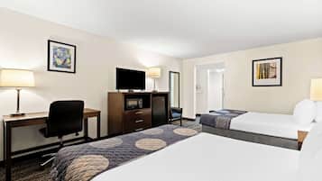 A hotel room with two beds, a desk with a chair, a television, and a dresser.