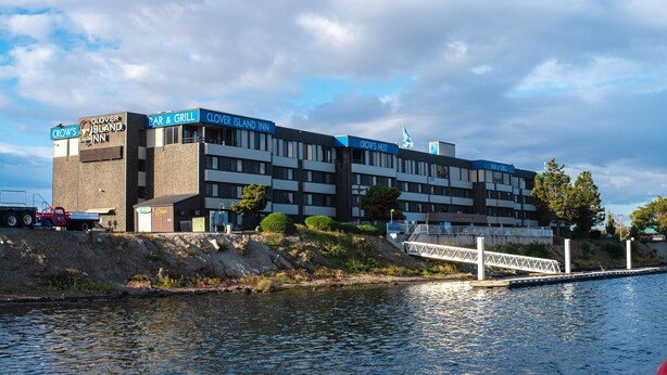 A multi-story building with signs for 'Crow's Inn' and 'Crow's Nest' bar & grill. - Clover Island Inn (Kennewick)