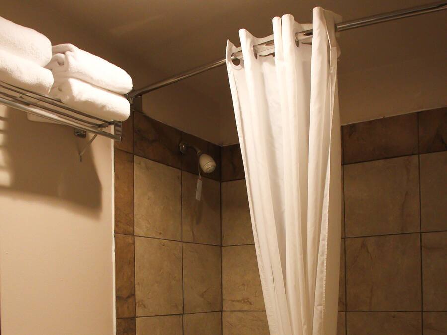 Een badkamer met bad, toilet en douchegordijn.
