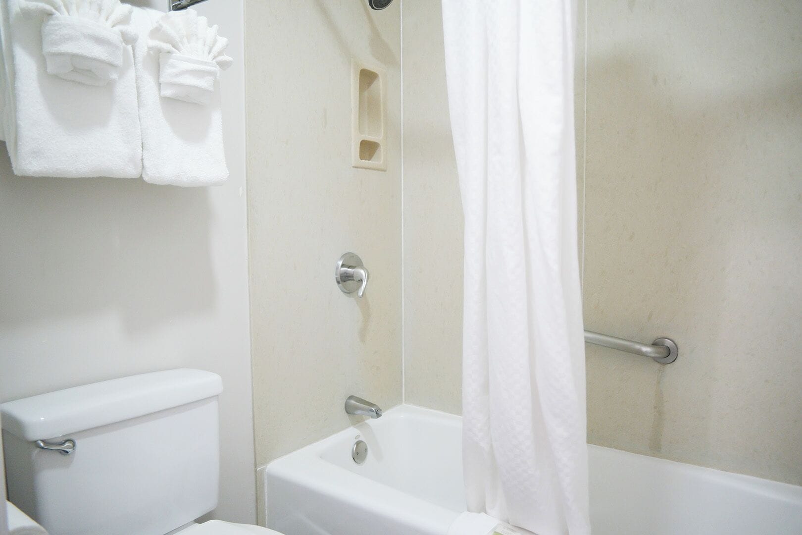 A bathroom with a toilet, bathtub, and shower curtain.