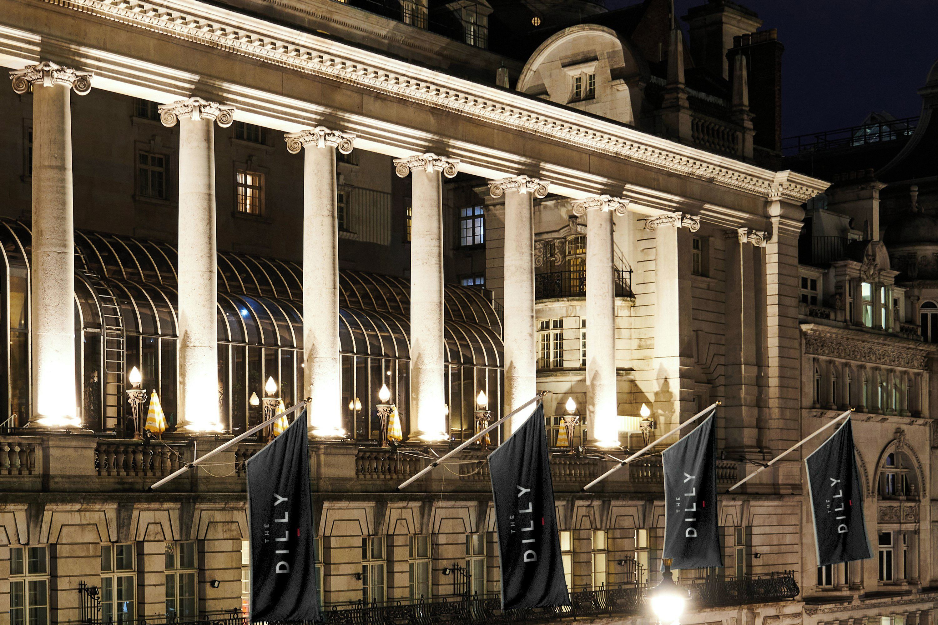 A classical building facade with columns and arches, illuminated by artificial lighting.