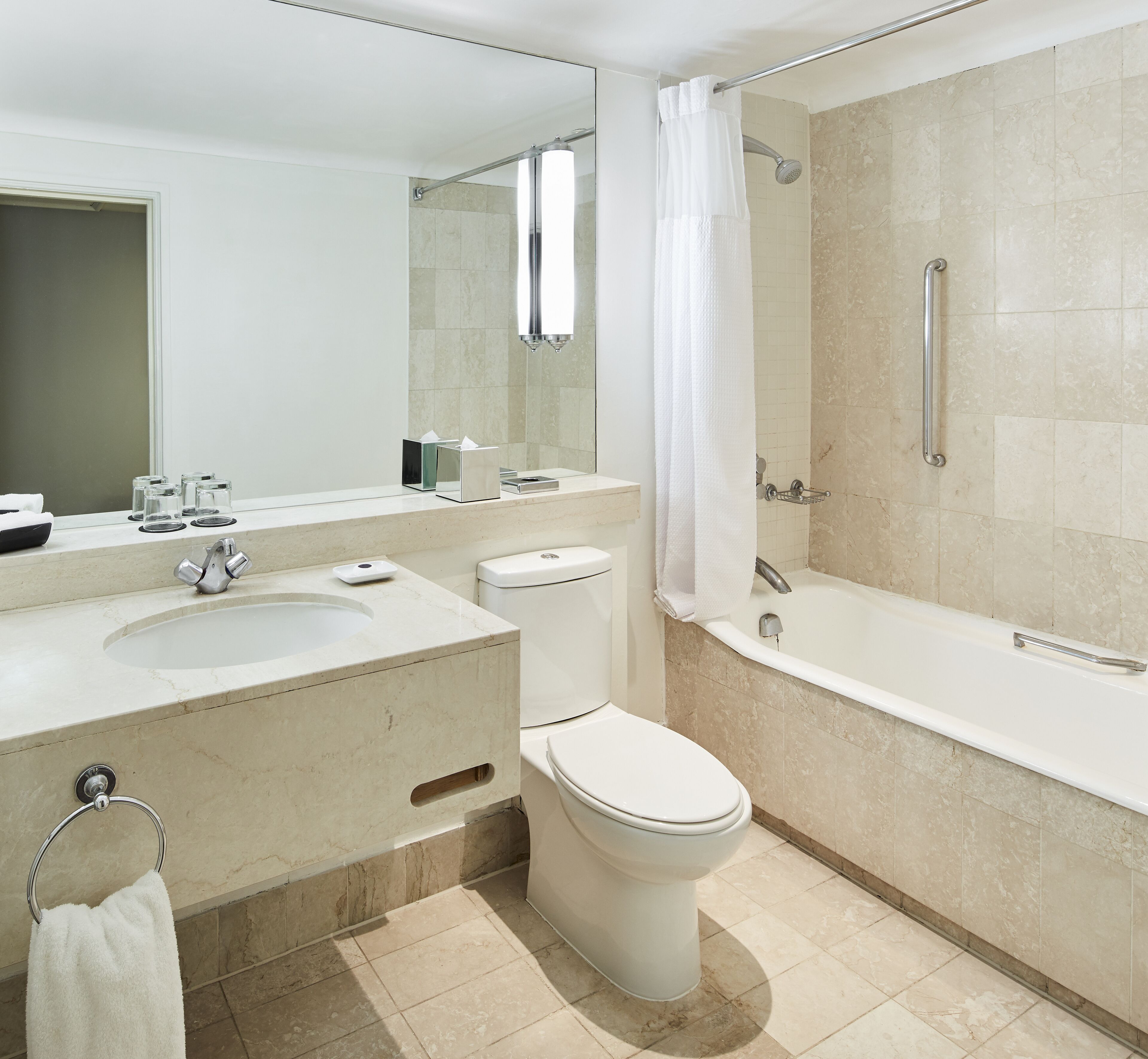 A modern bathroom with a sink, toilet, and bathtub.