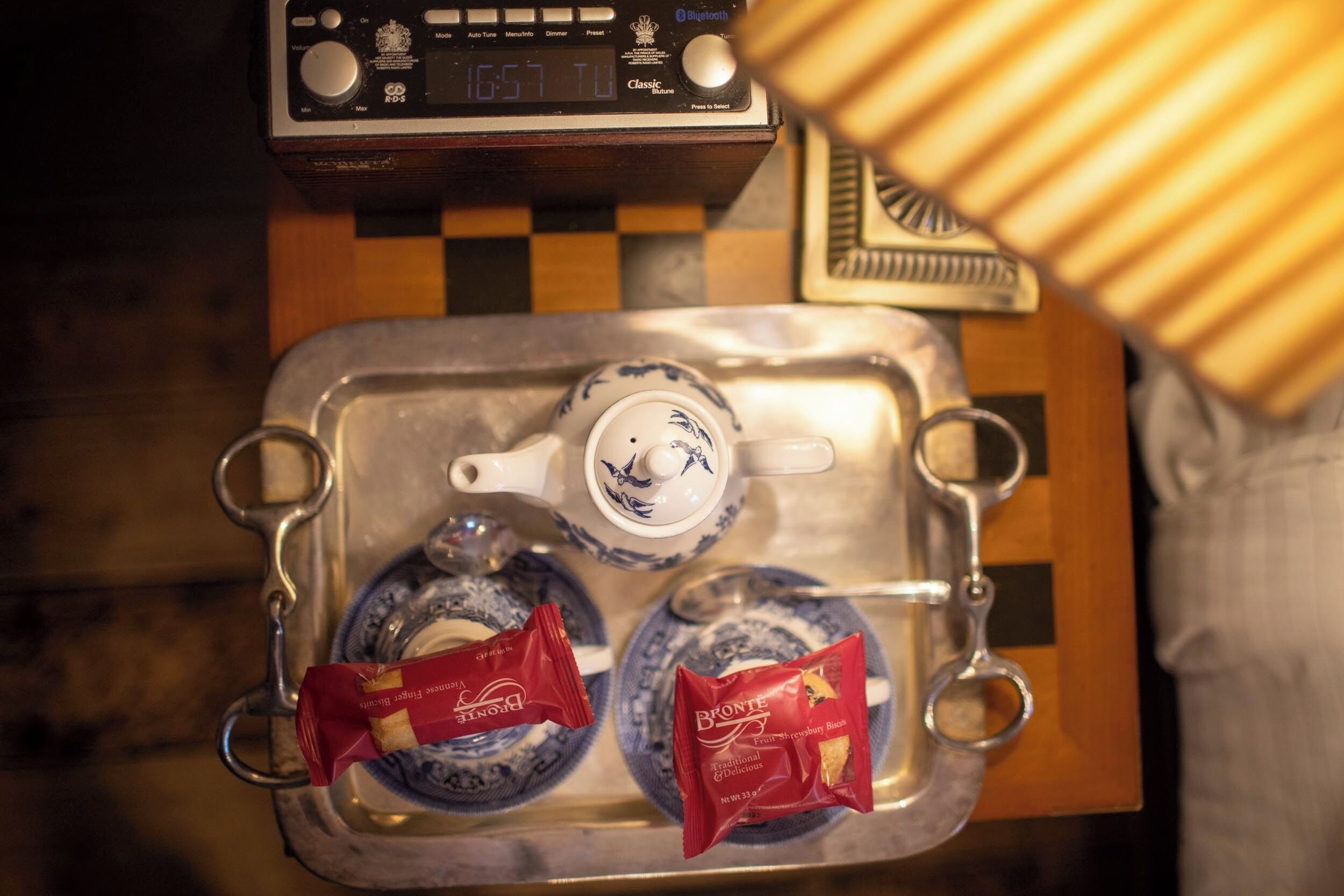 A tray with a teapot and two teacups on a table, accompanied by two packets of Bronte tea.