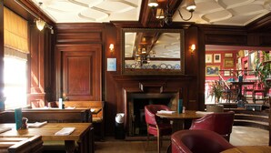 A traditional inn with wooden furnishings, a fireplace, and a dining area. - Crown Hotel (Blandford Forum)