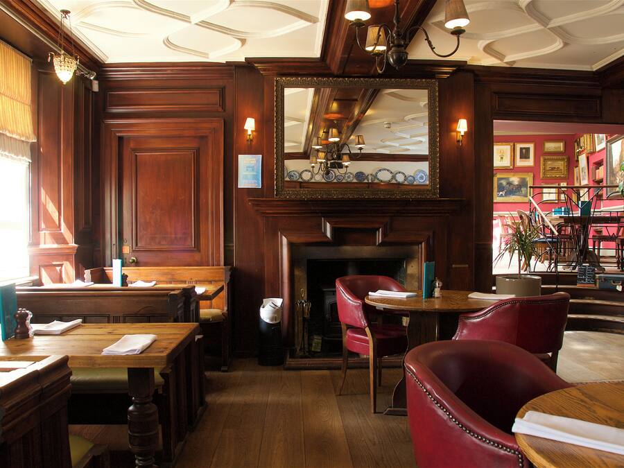 Ein traditionelles Gasthaus mit Holzmöbeln, einem Kamin und einem Essbereich.