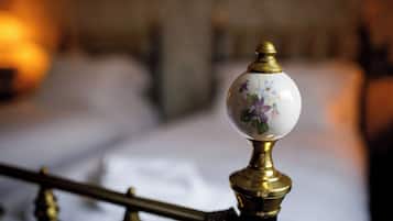 A close-up of a brass and porcelain balustrade with floral designs.
