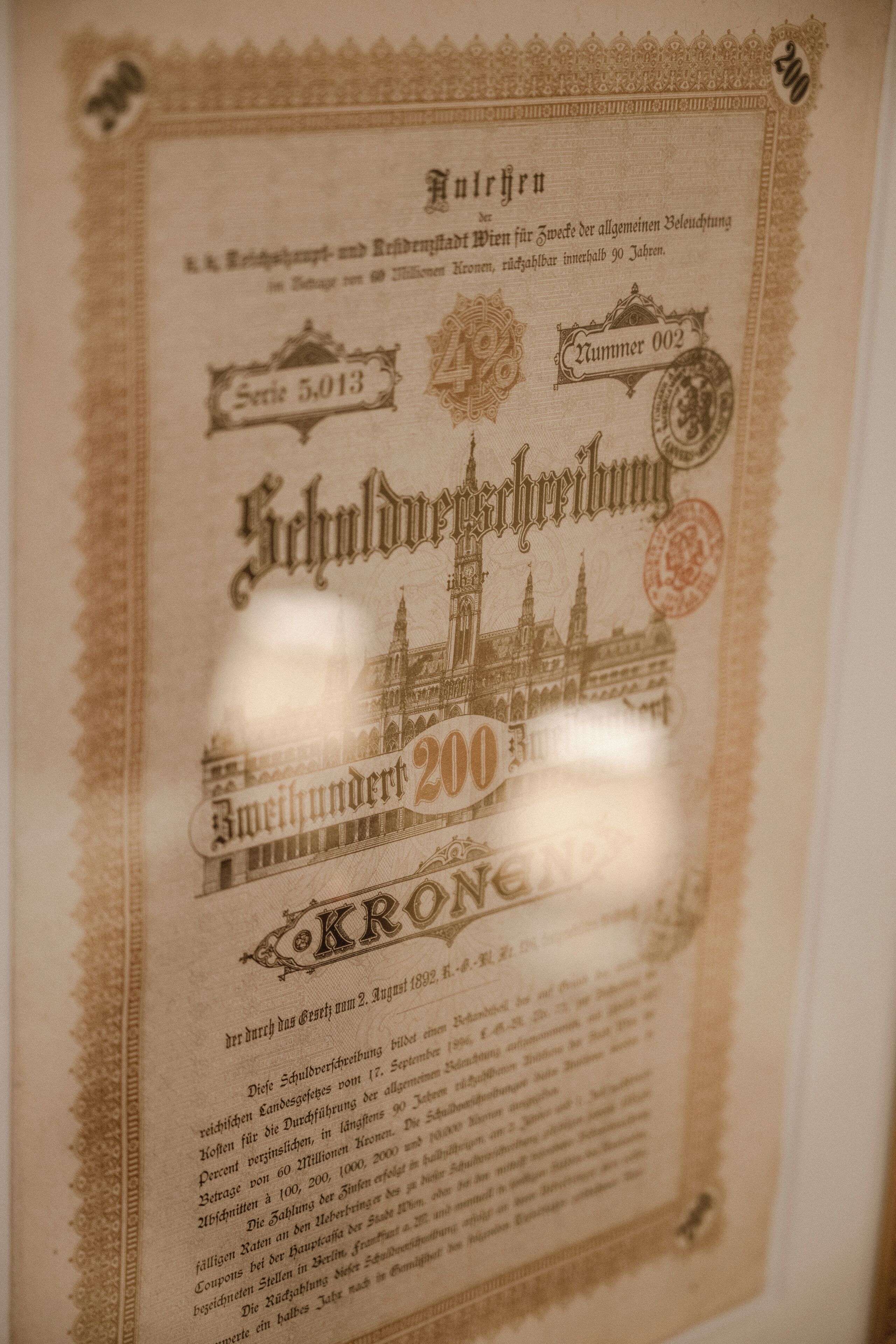 A historical document with ornate borders and text, featuring a prominent building illustration and the number 200.