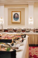 A banquet hall with a long table set for a meal, covered with various dishes and covered with glass cloches.