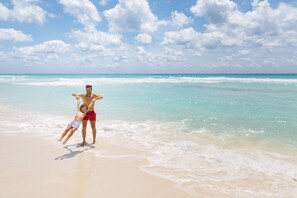 On the beach, white sand, sun loungers, beach umbrellas