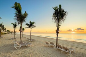 On the beach, white sand, sun loungers, beach umbrellas
