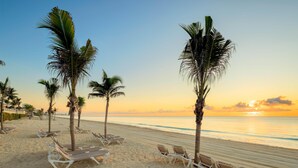 A beach with palm trees and sun loungers. - Occidental Tucancún All Inclusive (Cancun)