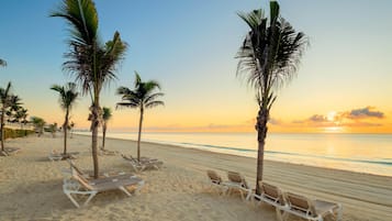 On the beach, white sand, sun-loungers, beach umbrellas