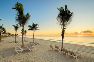 On the beach, white sand, sun loungers, beach umbrellas