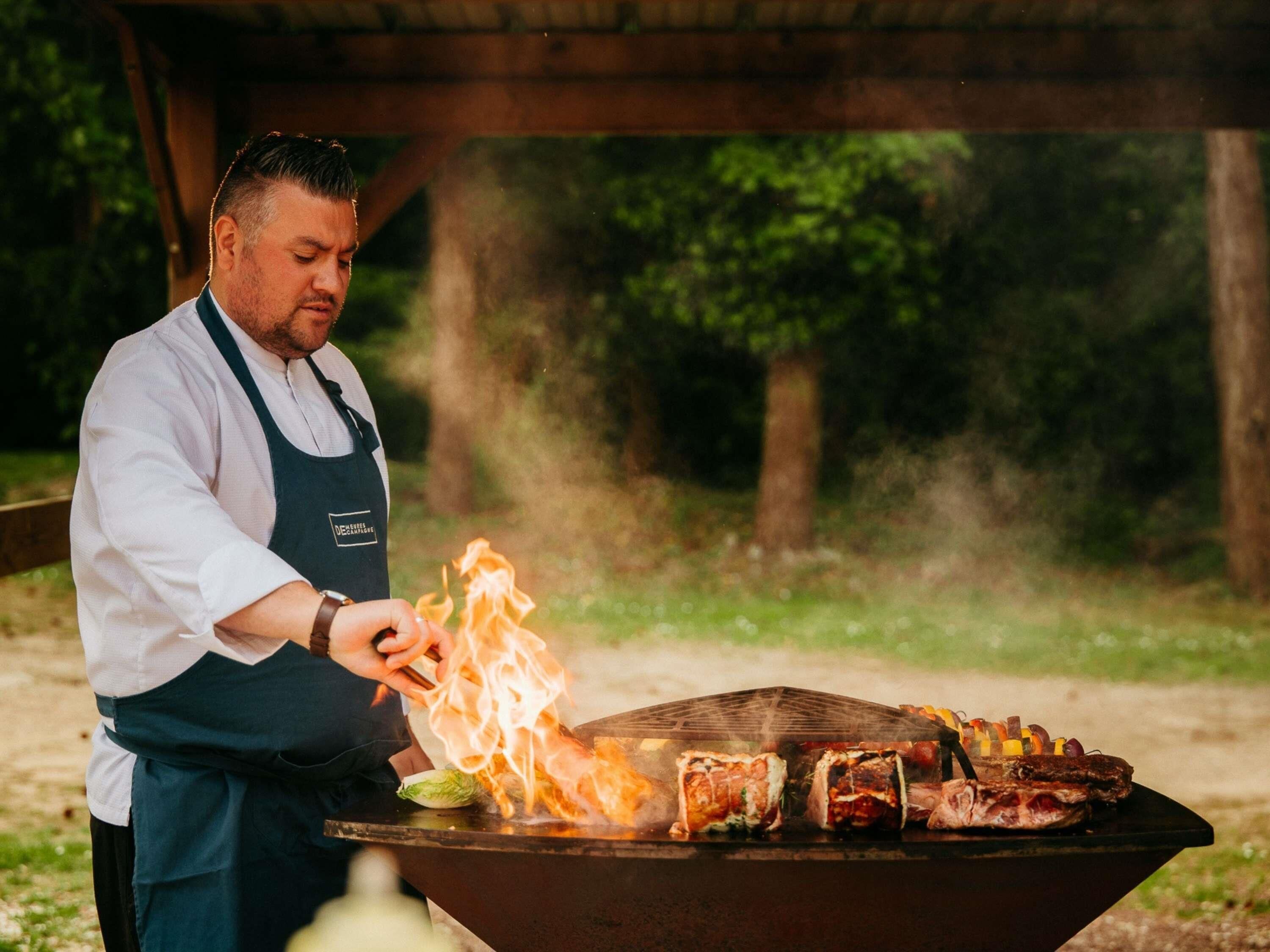A person grilling meat outdoors.