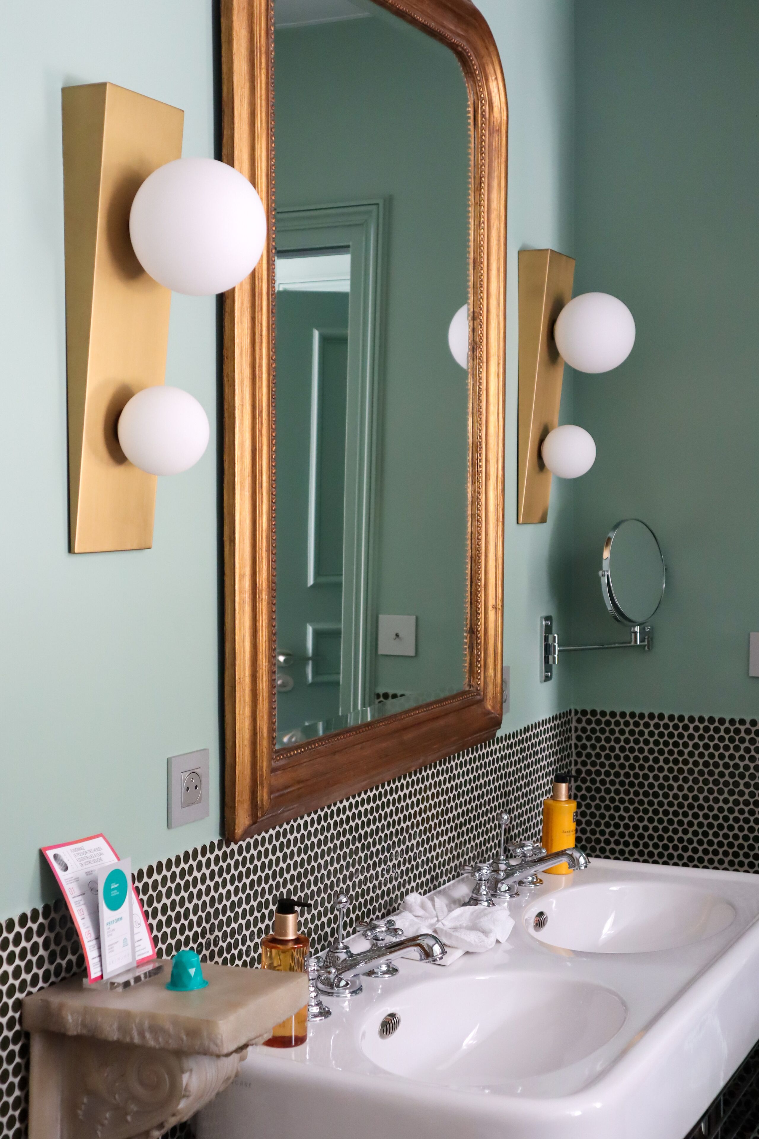 A bathroom with a large mirror, two sinks, and a towel rack.