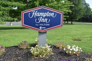 A Hampton Inn by Hilton sign with an arrow pointing left.