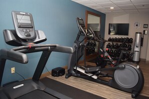 A gym with exercise equipment including a treadmill, elliptical, and weight machines. - Hampton Inn Rochester-Greece (Rochester)