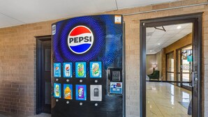 Ein Getränkeautomat mit Pepsi-Logo, verschiedenen Getränkeauswahlen und einer Münzeinwurföffnung.