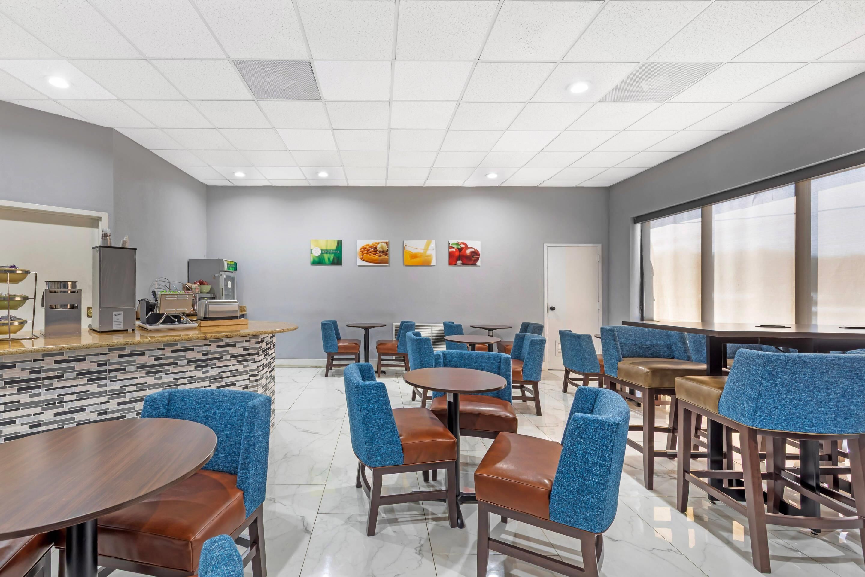 A modern dining area with a counter, seating, and artwork on the wall.