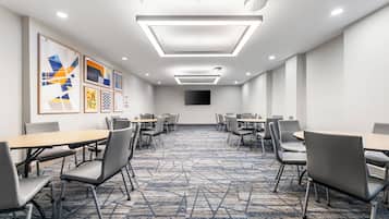 A conference room with a geometric carpet, modern lighting, and framed artwork on the walls.
