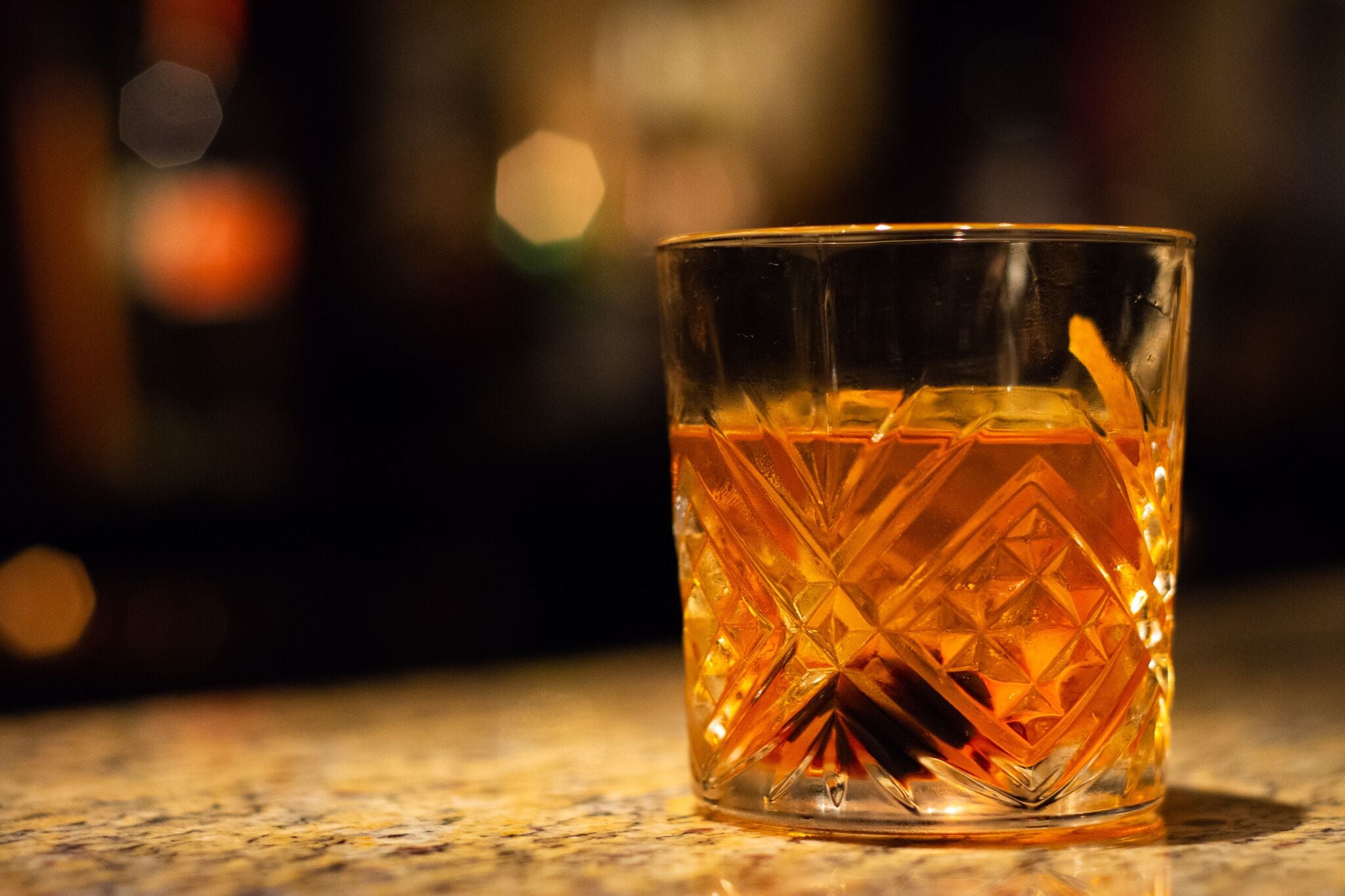 A clear glass with a geometric pattern, placed on a surface.