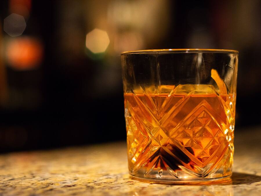 A clear glass with a geometric pattern, placed on a surface.