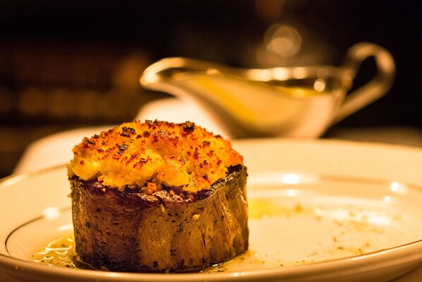 A single baked item on a plate with a gravy boat in the background. - Weber's Hotel & Restaurant (Ann Arbor)