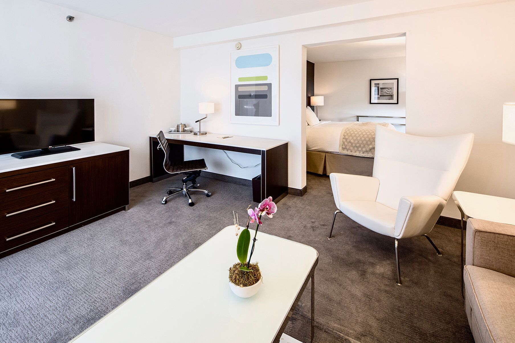 Une chambre d’hôtel équipée d’une télévision, d’un bureau, d’une chaise et d’un lit.