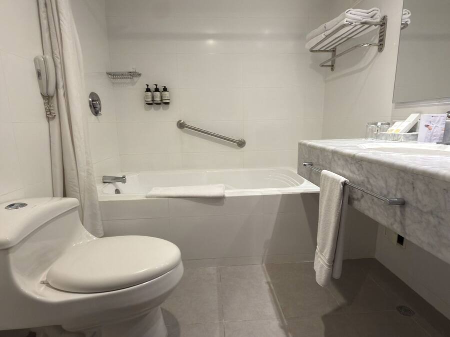 Un baño moderno con inodoro, ducha y lavamanos.