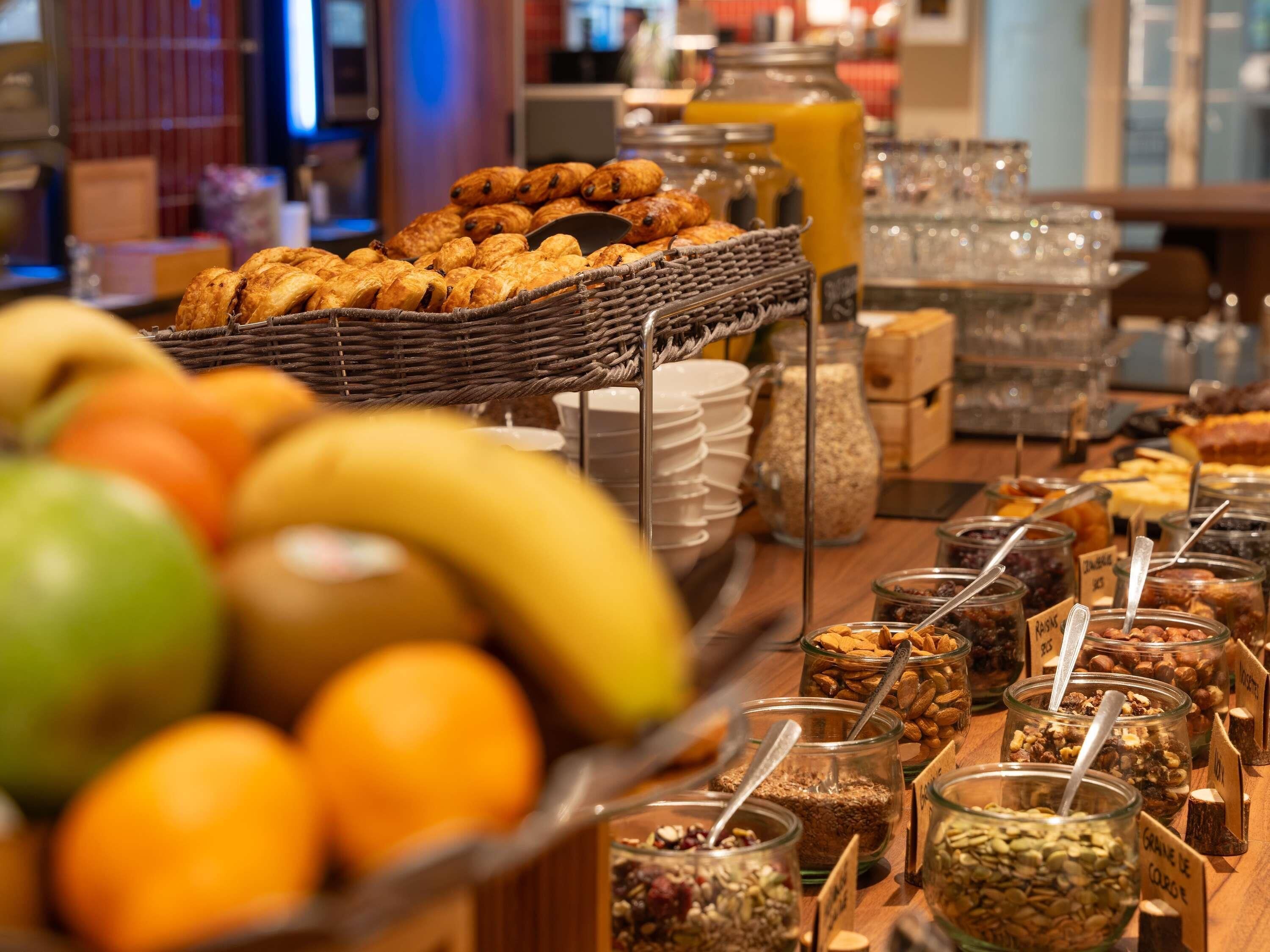 Buffet amb diferents aliments, com fruita, pastissos i una selecció de fruits secs i cereals.
