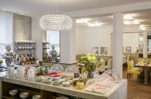 Disposição de buffet com diversos alimentos e um lustre decorativo.