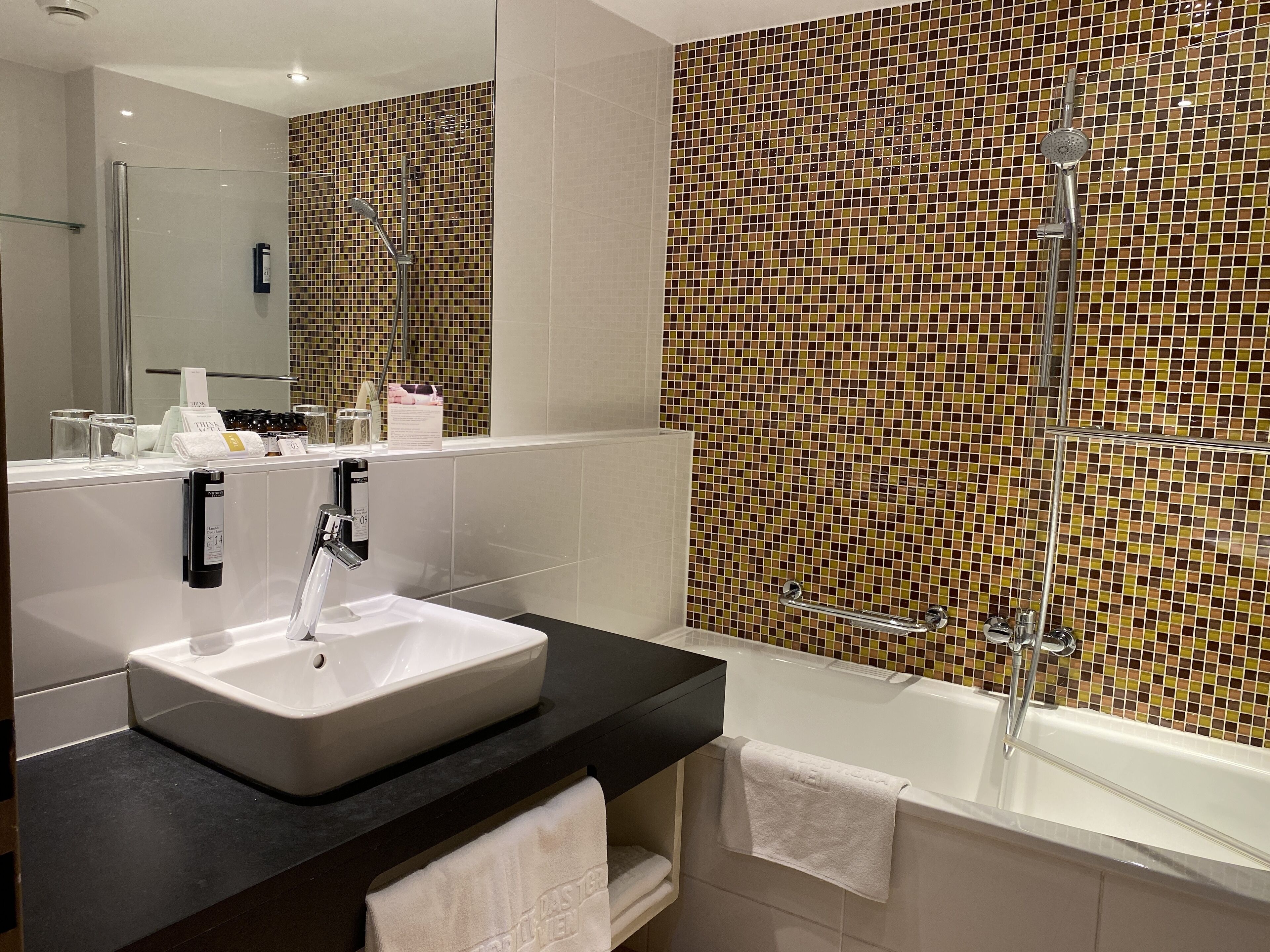 Un bagno moderno con un lavandino ampio, una vasca e una doccia.