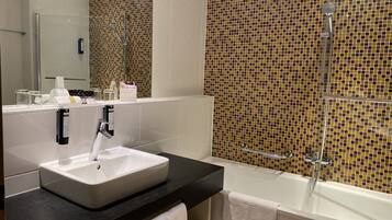 Un bagno moderno con un lavandino ampio, una vasca e una doccia.