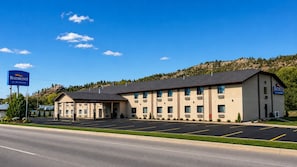 A Baymont by Wyndham hotel with a parking lot and a mountainous backdrop. - Baymont by Wyndham Hot Springs (Hot Springs)