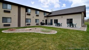 A modern building with multiple windows and a flat roof. There is a patio area with outdoor furniture. - Baymont by Wyndham Hot Springs (Hot Springs)